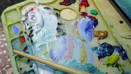 Artist copyist paint seascape with ship in ocean. Craftsman decorator draw as boat sail on blue sea with acrylic oil color. Draw finger, brush, knife palette. Indoor. Close up cinematic look.