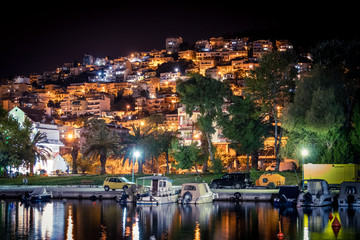 Fototapeta premium Residential houses on the seashore near the bay with boats. Greece.