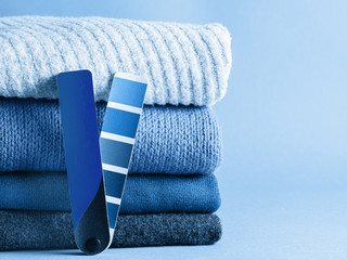 Stack of sweaters and color fun palette in classic blue 2020 color. Color of year 2020 concept for fashion and clothing industry. Copy space