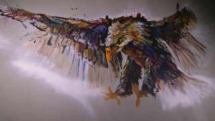Artist designer draws an eagle on the wall. Craftsman decorator paints a picture with acrylic oil...