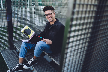 Student with diagrams and schemes in notebook looking at camera