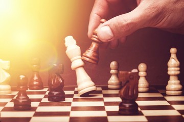 Human hand playing chess, buisness strategy concept