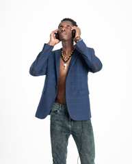 A black guy (man) in a blue jacket and jeans is listening music with headphones