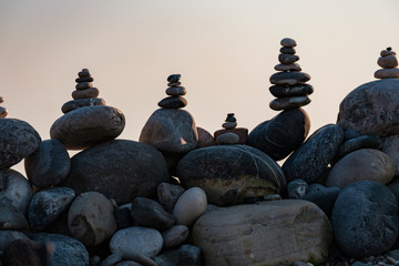 Fototapeta na wymiar stone pyramids standing on top of each other small and large stones on the beach