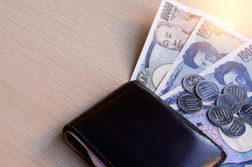 Japanese currency, Yen notes, money bags on a wooden table.