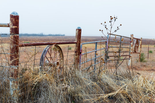 Rustic Fence With Wagon Wheel In Texas Farmland