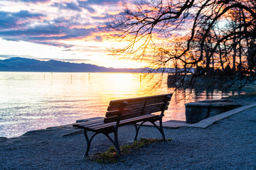 Sitzbank direkt am Ufer atmosphärische, strahlende, Sonnenuntergang, leuchtende  Wolken, glitzernde Wasserfläche, Lindau, Bodensee, Lindenhofpark