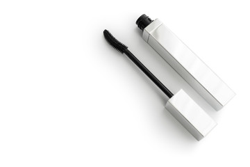 Black mascara wand applicator and tube on white background copy space template