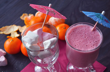 Hot winter drink with candies, Christmas or New Year decorations, dark background, rustic style, colored marshmallows.