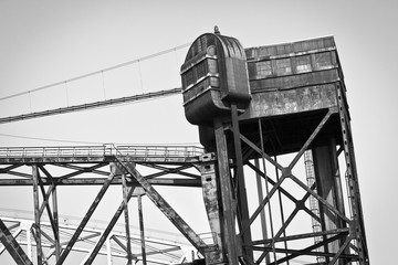 Greyscale low angle shot of a construction crane under the clear sky