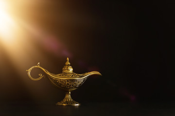 Fototapeta na wymiar Image of magical mysterious aladdin lamp with glitter sparkle smoke over black background. Lamp of wishes