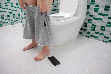 a person Leaving toilet Forget fall Mobile smart phone . Concept : Forget Phone / lost Phone , and...
