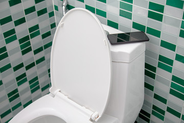 a person Leaving toilet Forget fall Mobile smart phone . Concept : Forget Phone / lost Phone , and...