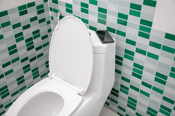 a person Leaving toilet Forget fall Mobile smart phone . Concept : Forget Phone / lost Phone , and...