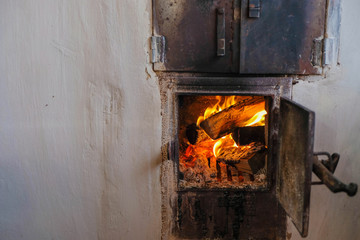 Traditional wood burning stove in the Ukrainian village.  Fire in the furnace. Copy space.