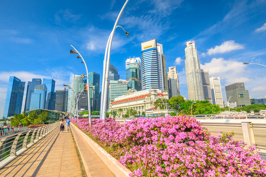 Singapore - April 28, 2018: Singapore downtown skyline with Fullerton Hotel, skyscrapers of Business District or CBD buildings and Esplanade Bridge in Marina Bay Promenade. Sunny day blue sky.