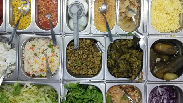 Display case with the ingredients for the dish in the metal containers. High angle shot