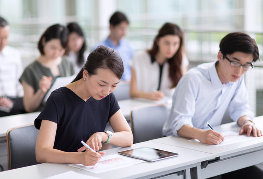 会議でメモを取るビジネスマンたち