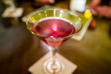 glass of red cosmopolitan martini on wooden table