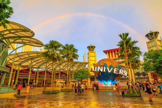 Singapore - May 2, 2018: rainbow after a thunderstorm in Sentosa at sunset. Universal Studios moving globe in Bull Ring square on background. Universal Studios first Hollywood movie theme park in Asia