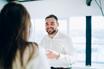 Young man smiling at friend at Christmas party