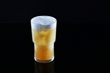A glass of Apple cider on a black background. Low-alcohol drink of yellow color.Macro photo. Copy space.