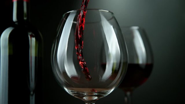 Super slow motion of pouring red wine into glass with rotate motion. Filmed on high speed cinema camera, 1000 fps