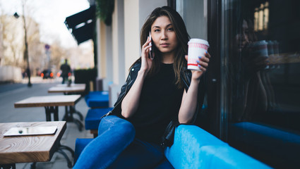 Stylish Asian woman talking on smartphone