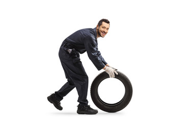 Auto mechanic rolling a car tire