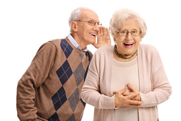 Senior man whispering to a senior woman