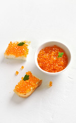 Red caviar on white stone background