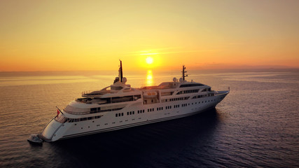 Fototapeta na wymiar Aerial drone photo of luxury yacht docked in Aegean deep blue sea at sunset with beautiful golden colours, Greece