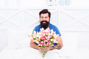 good morning flowers. Flowers are Perfect Pick-Me-Up to Boost Morning Mood. morning people concept. positive mood and happiness. happy bearded man in bed. birthday gift bouquet. spring fresh tulip