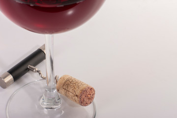 High angle view with shallow depth of field of a glass of red wine with a corkscrew.