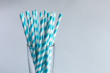 Blue straws for cocktails in a glass on a white background