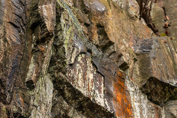Massive Felswand aus Schiefergestein mit Felsvorsprüngen, grünem Moos, schroffen Kanten und steilen Klippen zeigt ein Kletterparadies für Free Climbing, Kletterer und Wanderer durch felsiges Gebirge