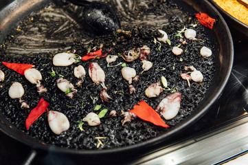 Spanish food. Black paella. San Miguel seafood market in MADRID