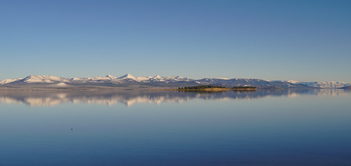 Panoramic shot of Yellowstone Lake and the snow covered Absaroka Mountain Range in the distance.