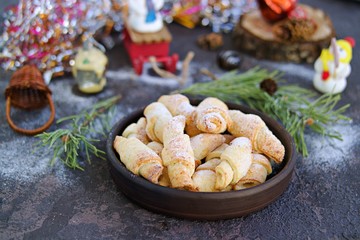 Cottage cheese cookies in the shape of bagels in a brown ceramic bowl on a dark concrete background in the New Year and Christmas style. Recipes with cottage cheese.