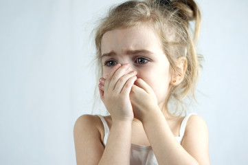 Little girl in a white top is crying. She has pain. Background, Selective Focus. She is scared and afraid. Fear