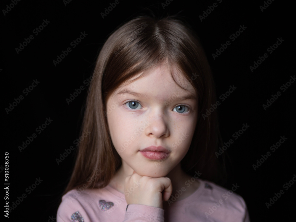 Wall mural portrait of a little beautiful girl with long hair on a black background