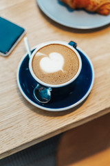 Close up of Freshly Brewed Coffee Cup on Wooden Table in Modern Cafe. Concept of Tasty Breakfast And Good Morning