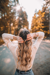 Young woman in forest during autumn with blonde hair locks 