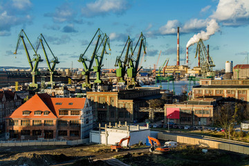 View of the shipyard and port - industry part of the city of Gdansk (Gdańsk) with shipyard constructions and cranes. Poland - obrazy, fototapety, plakaty
