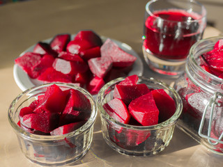 Cooked red slices beetroot in plate and glass bowls. Glass of beetroot juice