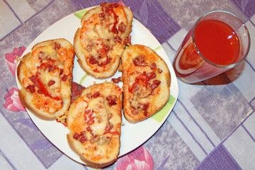 Fresh appetizing pizza with delicious ingredients and glass of tomato juice