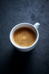 Cup of coffee on dark stone background. Close up. Copy space