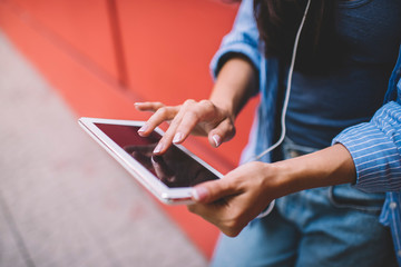 Cropped image of millennial woman using touch pad app during leisure time for communication in web networks connected to 4g wireless for surfing internet, selective focus on digital tablet