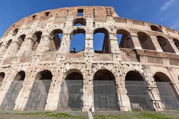 Obraz premium Part of the wall of the ancient Roman Colosseum against blue sky, Italy
