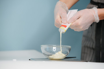 Focused blonde female hairdresser is running fingers through client's wet brown hair, preparing them for trimming. Close up. Cropped, customer's head only. She's peaceful, and relaxed.